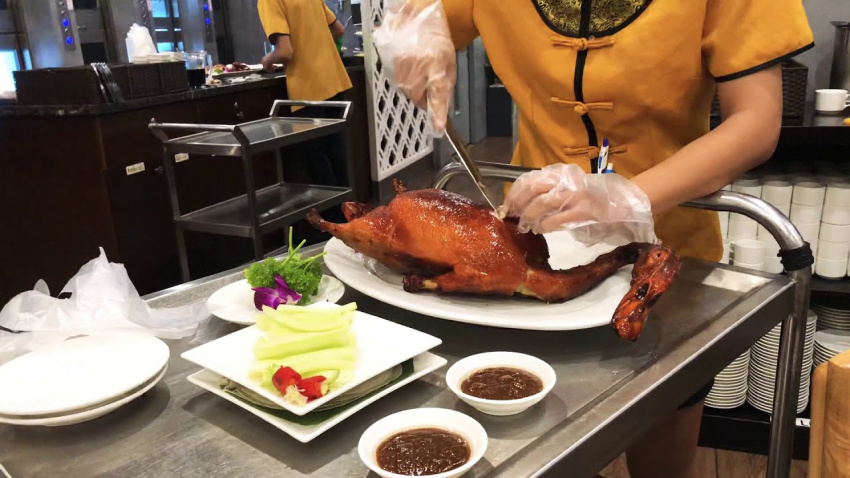 Đầu bếp phục vụ vịt quay tại bàn tại Quanjude, Bắc Kinh